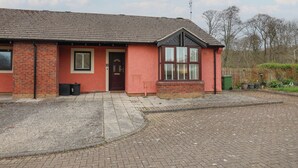 A red brick building with a dark roof, a front door, and a window with blinds. - Jubilee Two Bedroom Bungalow Pet Free (Penrith)