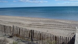 Una playa con una cerca de madera y una vista despejada del océano.