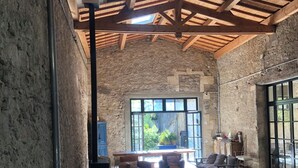 Una habitación amplia con un alto techo de madera, un ventanal grande y una mesa con ruedas.