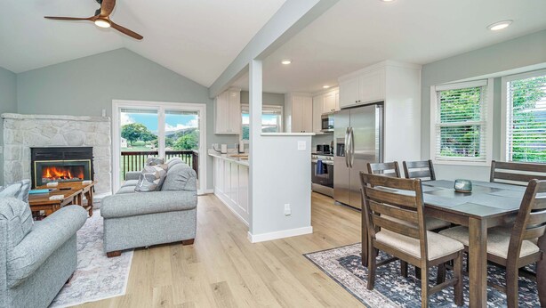 A spacious kitchen with a dining area, a fireplace, and a ceiling fan. - Family Fun Retreat, Games & Fire Pit, Near Eureka (Holiday Island)