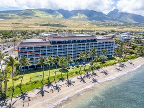 A hotel with multiple balconies, a beach, and mountains in the background. - Oceanfront Maui Escape! Panoramic Views, Pool, Hot Tub & Steps to Beach (Lahaina)