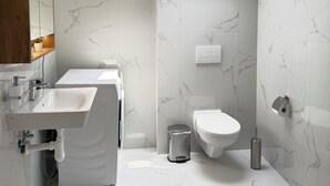 A modern bathroom with a skylight, a large sink, and a toilet. - Riverside Apartment 15 (Hlavní město Praha)