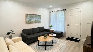 A modern living room with a sofa, a coffee table, and a painting on the wall.