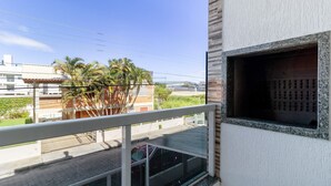 A balcony with a view of palm trees and a building in the background.