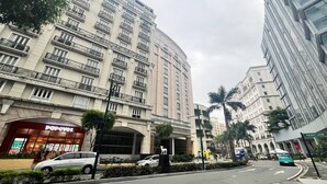 Un edificio de varios pisos con un restaurante 'Popeyes' destacado en la planta baja.