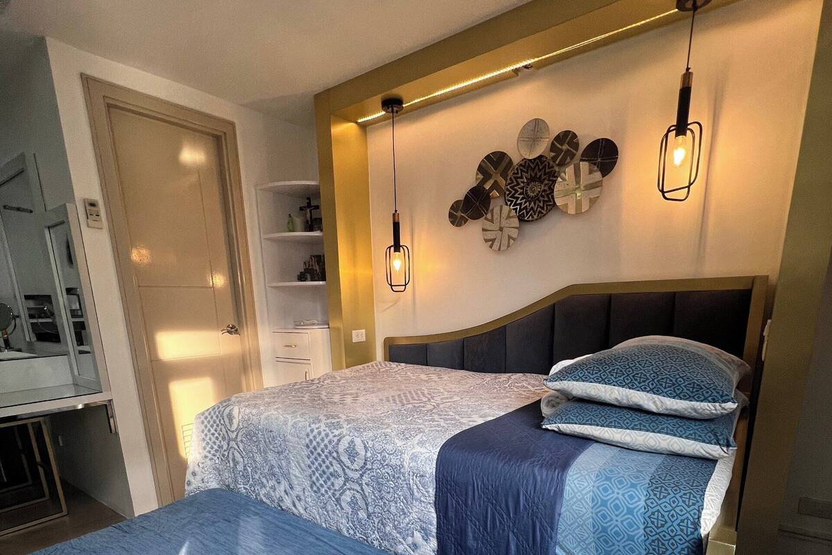 Un dormitorio con dos camas, un armario, un espejo y decoración en la pared.