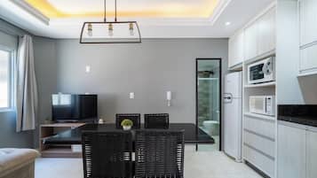 A modern kitchen with white cabinets, a black countertop, and a built-in microwave.