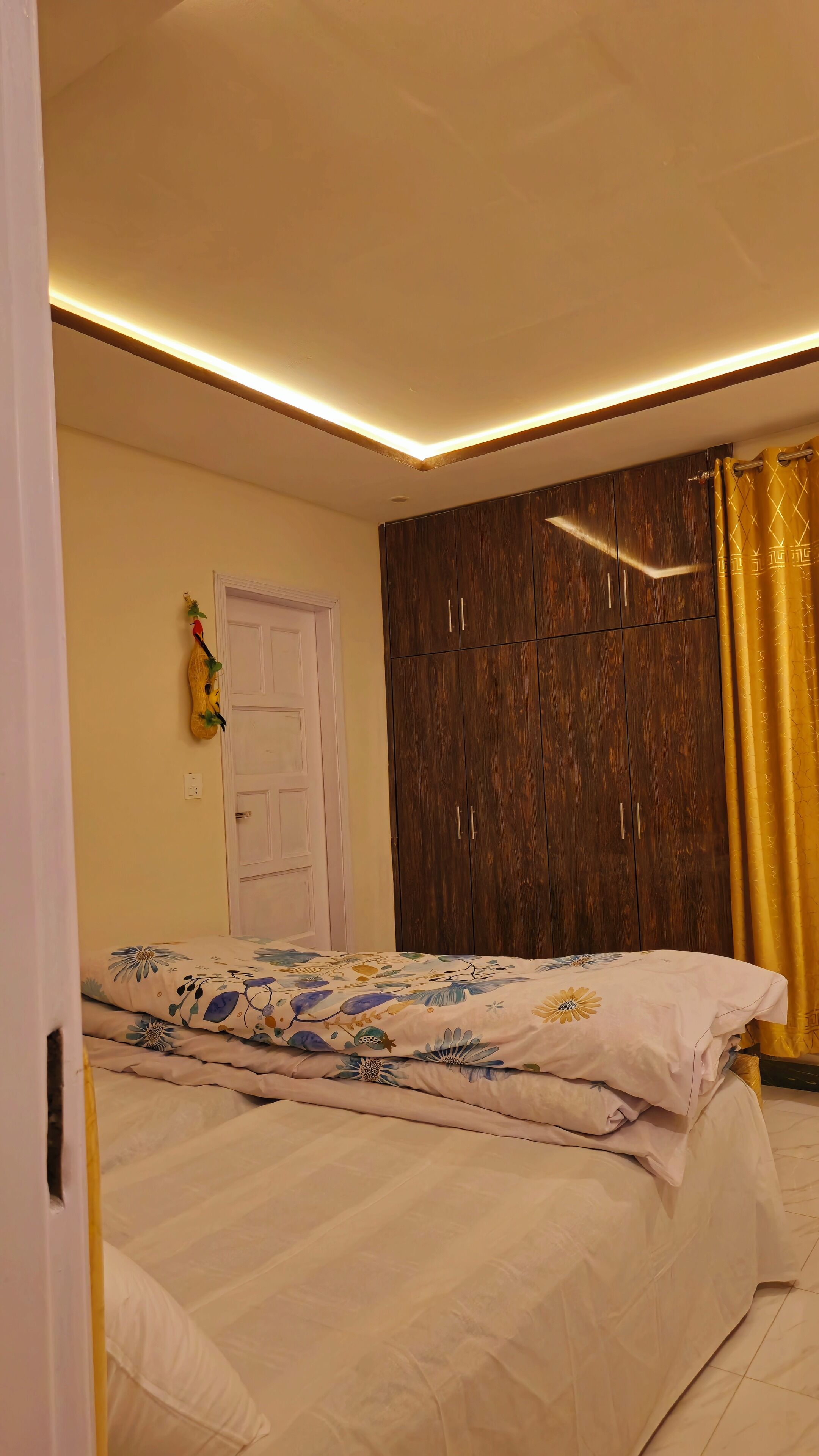 Een slaapkamer met een bed, een kledingkast en een deur.