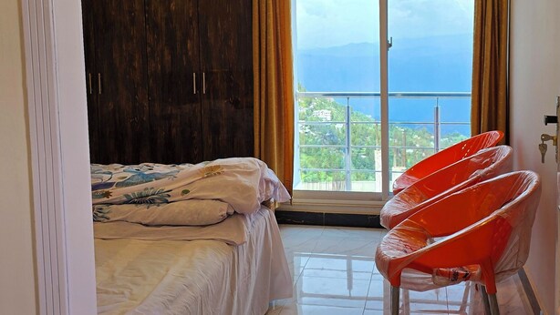 Un dormitorio moderno con una cama grande, un armario y vista al mar.
