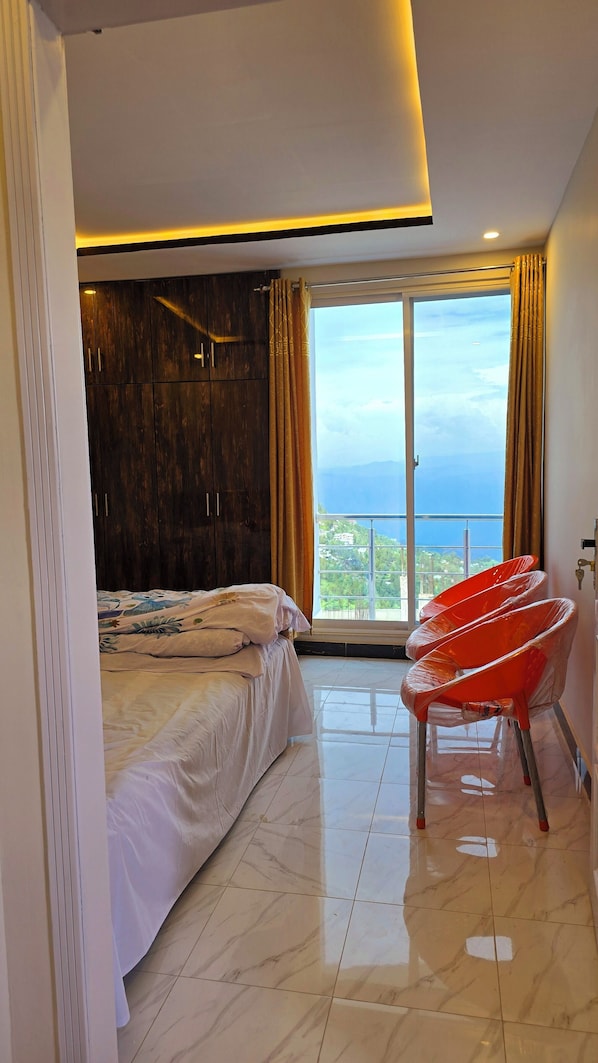 Un dormitorio moderno con una cama grande, un armario y vista al mar.