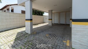 Ένας σκεπαστός εξωτερικός χώρος με πλακάκι στο δάπεδο, λευκούς τοίχους και έναν τοίχο σε μπεζ χρώμα.