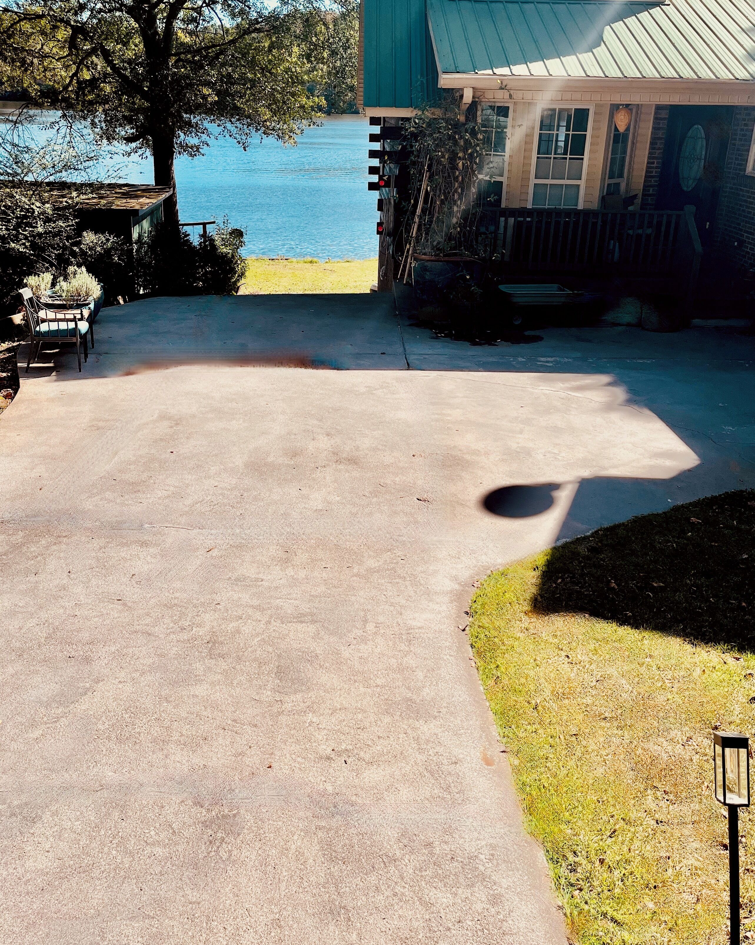 Un camino pavimentado que conduce a una casa con vista al lago.