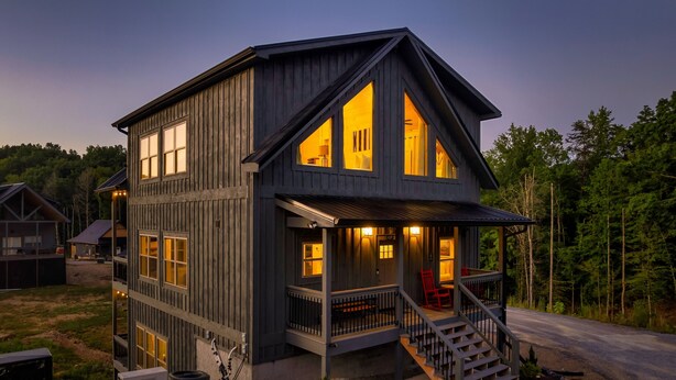 A two-story wooden house with a porch, large windows, and a staircase leading to the entrance. - NoBunks! 7Beds•Spacious & Near Parkway/Attractions (Pigeon Forge)
