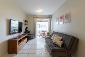Basic Apartment | Living area | 32-inch Smart TV with digital channels - Condomínio bem localizado a 100m da Praia - CSC (Florianópolis)