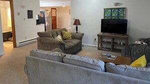 A living room with a sofa set, a television, and a lamp. - Trails, Tails & Town – Pet-Friendly Stay Near It All (Helena)
