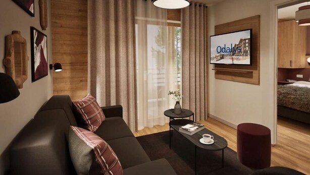 Ein modernes Wohnzimmer mit einer Couch, einem Couchtisch und einem an der Wand montierten Fernseher.