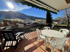 A patio with a table and chairs, a brick floor, and a view of a mountainous landscape. - Ground floor, view ski slopes, terrace, parking, tv, ski locker, 22m², Praz sur Arly (Praz-sur-Arly)