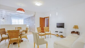 A modern living room with wicker furniture, a flat-screen TV, and a white sofa. - Apt one Block sea 260m Praia dos Ingleses Rie0315 (Florianópolis)