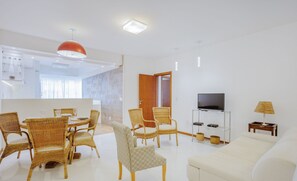 A modern living room with wicker furniture, a flat-screen TV, and a white sofa. - Apt one Block sea 260m Praia dos Ingleses Rie0315 (Florianópolis)