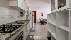 A kitchen with white cabinets, a granite countertop, a gas stove, and a refrigerator. - Apt 500m From Ingleses Beach, Floripa Rid3106 (Florianópolis)