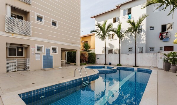 A residential building with a swimming pool, outdoor seating, and a small garden area. - Apt 500m From Ingleses Beach, Floripa Rid3106 (Florianópolis)