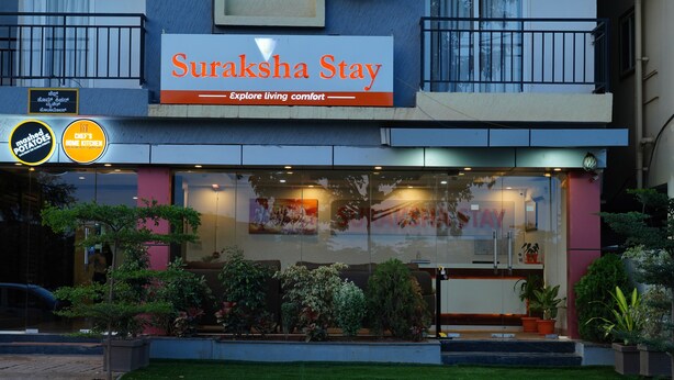 A hotel named Suraksha Stay with a sign indicating it offers living comfort. - Suraksha Stay ITPL Hotel (Bengaluru)