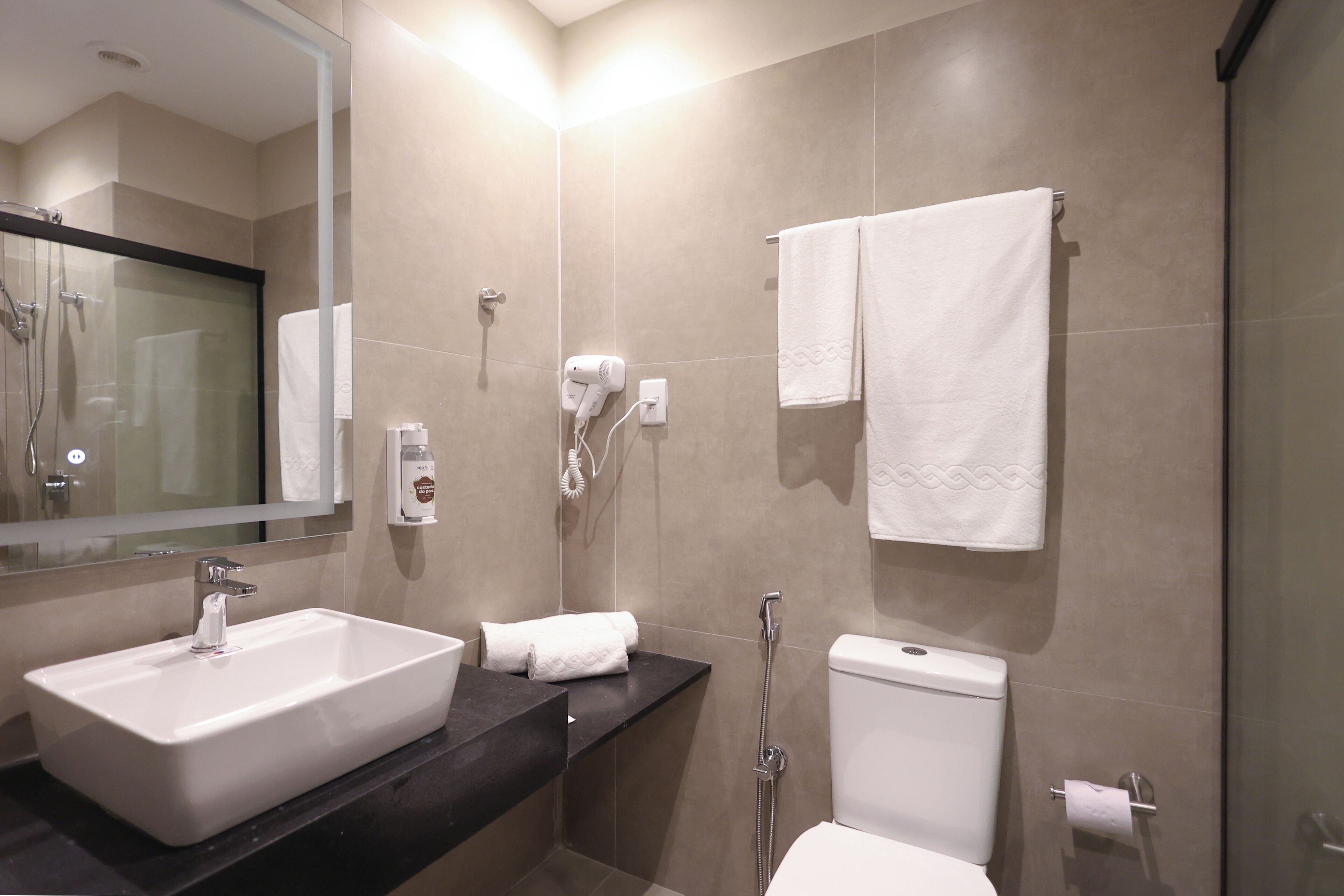 A modern bathroom with a rectangular sink, a toilet, a glass-enclosed shower, and a towel rack.