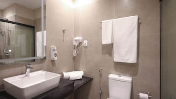 A modern bathroom with a rectangular sink, a toilet, a glass-enclosed shower, and a towel rack.