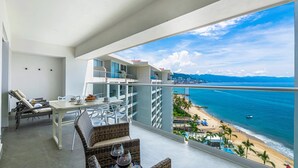 Un balcon avec vue sur une plage et l’océan.