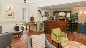 Un hall de hotel con zona de bar, asientos y vistas al exterior.