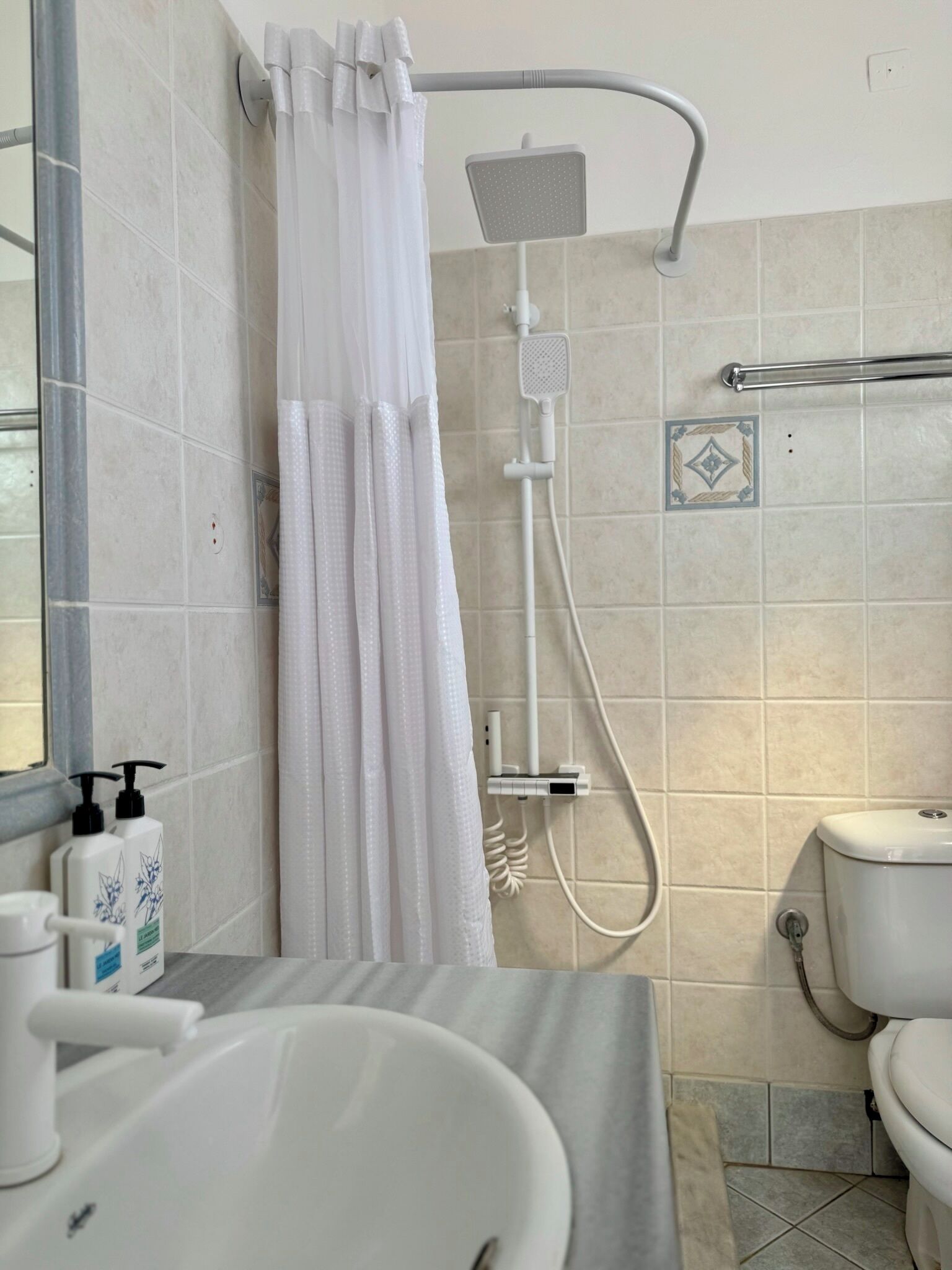 Un ba ño con ducha, inodoro y lavabo.