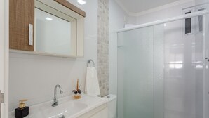 A modern bathroom with a white sink, a mirror, and a glass shower enclosure. - Cozy Apartment 5 Mi From the Beach, Floripa Ece104 (Florianópolis)