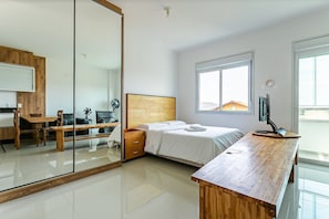 Une chambre à coucher moderne avec un lit en bois, un bureau, une chaise, une armoire et une grande fenêtre.