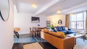 A modern living room with a sofa, coffee table, and dining area.