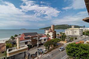 A coastal town with buildings, a beach, and a view of the sea. - Charming Apt With Balcony and Sea View Edj0410 (Florianópolis)