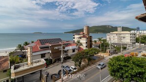 A coastal town with buildings, a beach, and a view of the sea. - Charming Apt With Balcony and Sea View Edj0410 (Florianópolis)