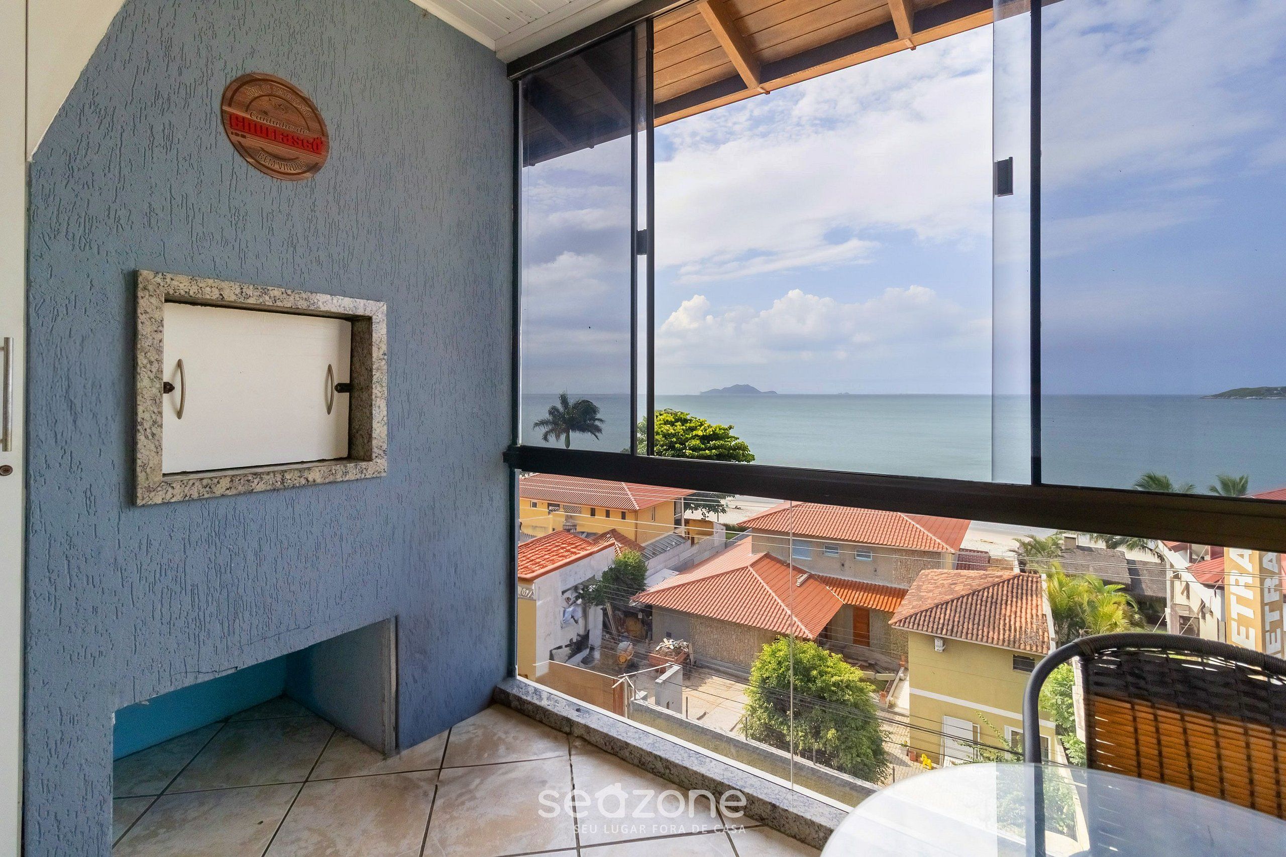 A balcony with a view of the sea and buildings.