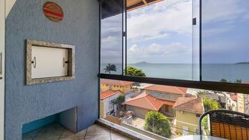 A balcony with a view of the sea and buildings.