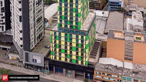 A multi-story building with a distinctive checkered facade, surrounded by other urban structures. - City-view apartment in Chapinero – fast WiFi, 24h security, gym & coworking (Bogotá)