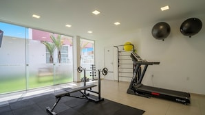A gym with a bench press, a treadmill, and a pull-up bar. - Apt Close to Beach & Floripa Shopping [eaz305] (Florianópolis)
