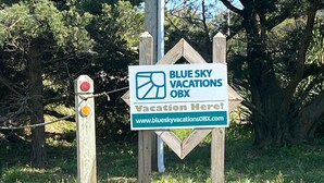 Schild für Blue Sky Vacations OBX mit einer Website-URL.