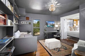 A modern bedroom with a desk, a bed, and a bookshelf.
