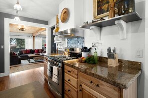 A modern kitchen with granite countertops, stainless steel appliances, and wooden cabinetry. - White Moon Ranch with Panorama River Views (Rifle)