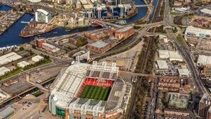 Une vue aérienne d’une ville avec un stade, une rivière et les bâtiments environnants.