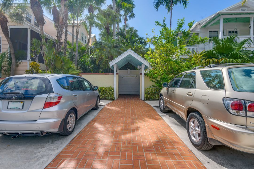A gated driveway leading to a building with a covered entrance.