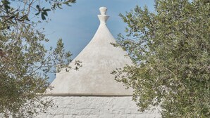 Un bâtiment blanc avec un toit en forme de pyramide et une porte portant l’inscription « 105 ».