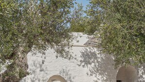 Un bâtiment en pierre doté d’une porte en arc de cercle et d’une petite fenêtre.