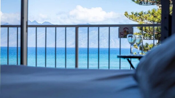 Une chambre avec vue sur l’océan et les montagnes.