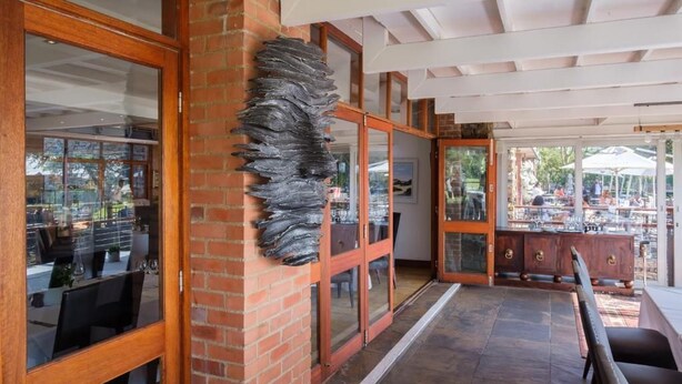 Un espace de restauration intérieur avec des murs en briques, des meubles en bois et une cloison en verre.