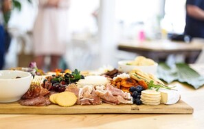 Una tabla de fiambres con diferentes carnes, quesos y frutas.